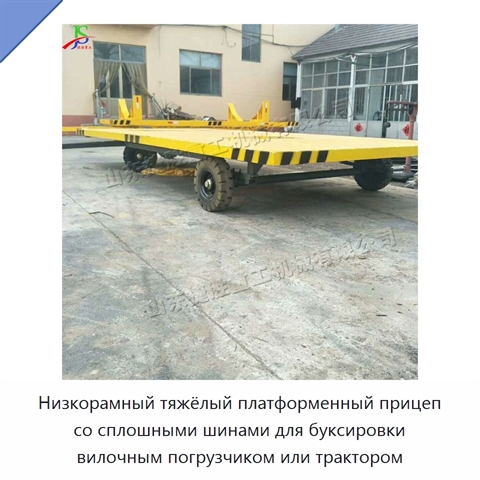 Низкорамный тяжёлый платформенный прицеп со сплошными шинами для буксировки вилочным погрузчиком или трактором