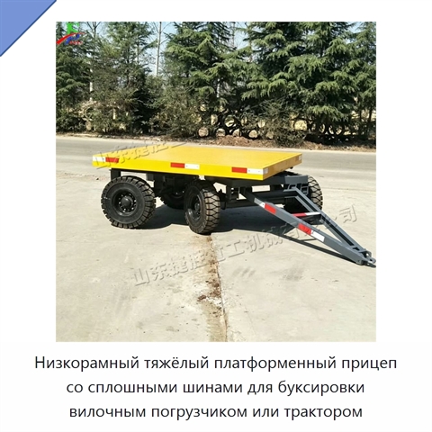 Низкорамный тяжёлый платформенный прицеп со сплошными шинами для буксировки вилочным погрузчиком или трактором